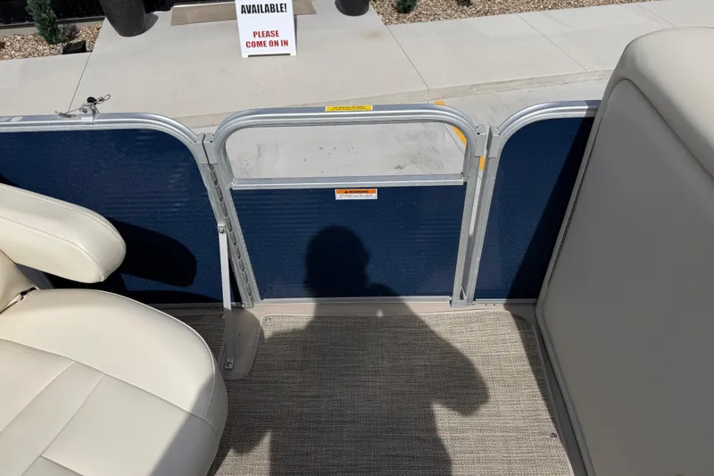 Slide: The Image of 2018 Godfrey Sweetwater 2486 SB boat interior with seating and gate, shadow visible. - 22