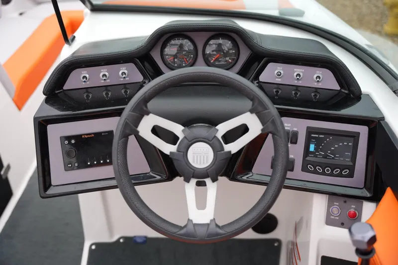 Slide: The Image of 2021 MasterCraft NXT24 boat dashboard with steering wheel and control panels. - 10