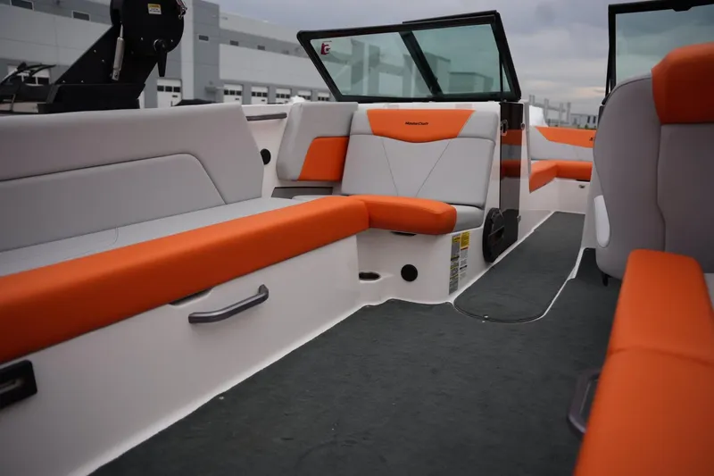 Slide: The Image of 2021 MasterCraft NXT24 boat interior with orange and white seating, modern design. - 16