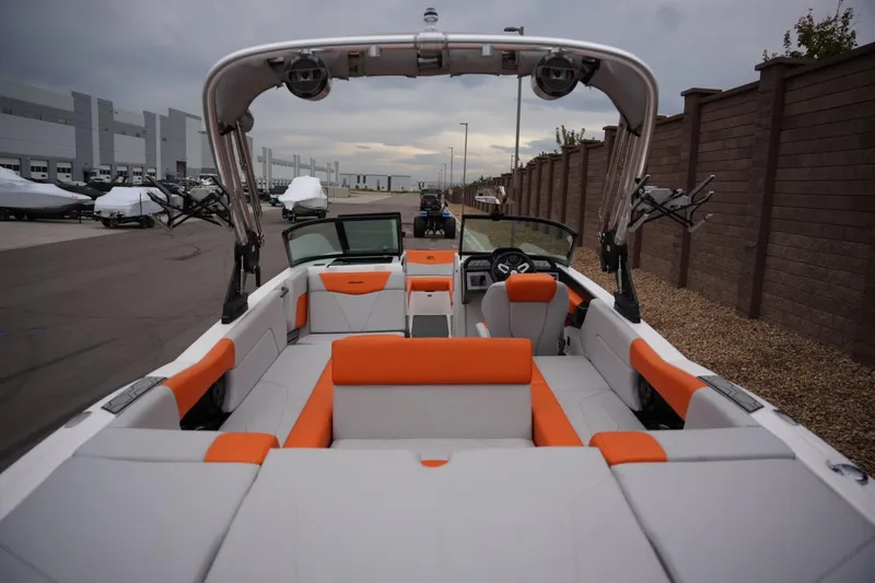 Slide: The Image of 2021 MasterCraft NXT24 boat with orange and gray interior, parked outdoors. - 19