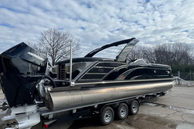 Slide: The Image of 2023 Bennington 30 QXFBAX2 pontoon boat on trailer, featuring Mercury outboard motor. - 3