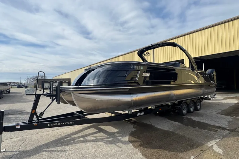 Slide: The Image of 2023 Bennington 30 QXFBAX2 pontoon boat on trailer, parked outside a warehouse. - 6