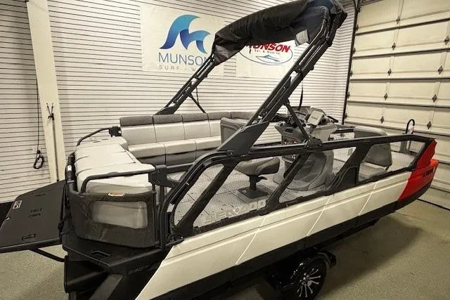 Slide: The Image of 2022 Sea-Doo Switch Cruise 21 pontoon boat in showroom, featuring modern design and seating. - 16