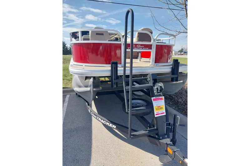 Slide: The Image of 2025 Sun Tracker Bass Buggy 16 DLX pontoon boat on trailer, red exterior. - 6