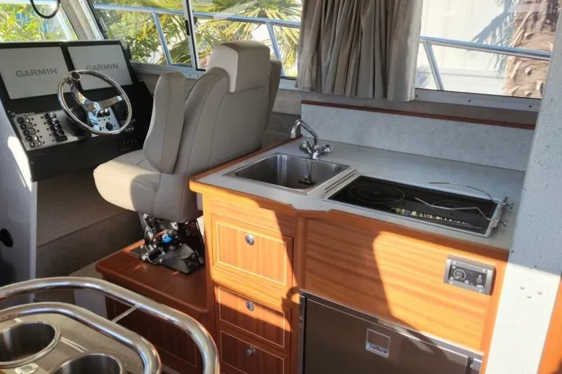 Slide: The Image of Interior of 2023 KingFisher 3025 Destination boat with helm, sink, and stove. - 11