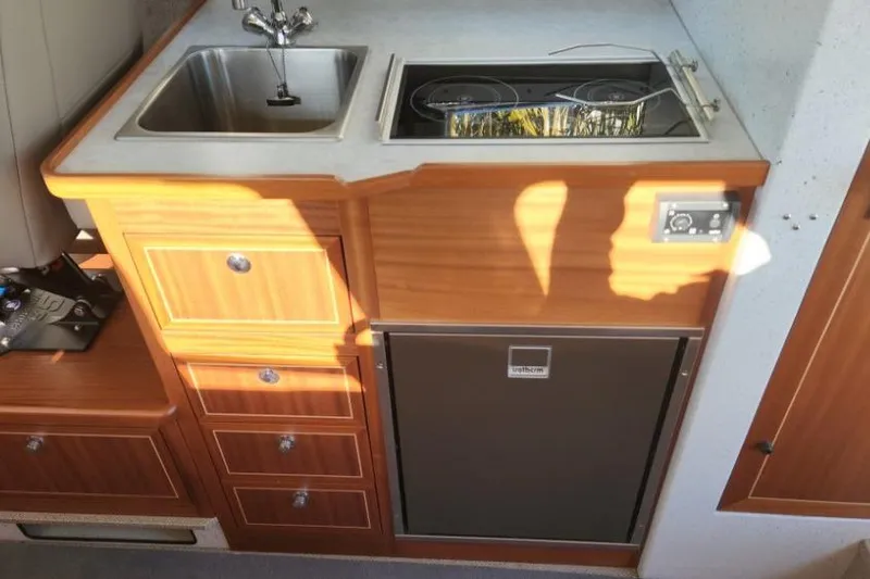 Slide: The Image of Compact kitchen area in 2023 KingFisher 3025 Destination boat with sink, stove, and fridge. - 17