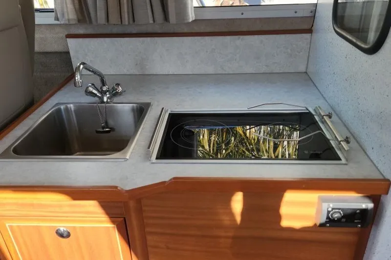 Slide: The Image of Compact kitchen area in 2023 KingFisher 3025 Destination boat with sink and stove. - 18