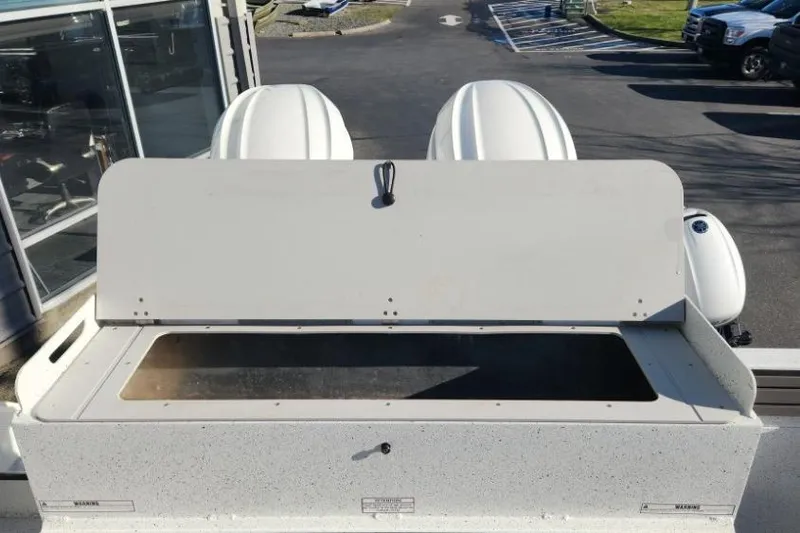 Slide: The Image of 2023 KingFisher 3025 Destination boat with open storage compartment, parked outdoors. - 23