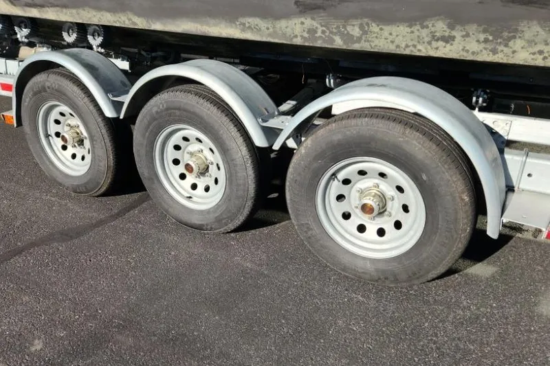 Slide: The Image of Triple axle trailer for 2023 KingFisher 3025 Destination boat on asphalt surface. - 24