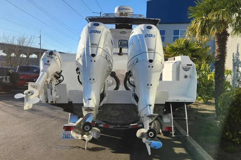 Slide: The Image of 2023 KingFisher 3025 Destination boat with dual outboard motors, parked outdoors. - 5