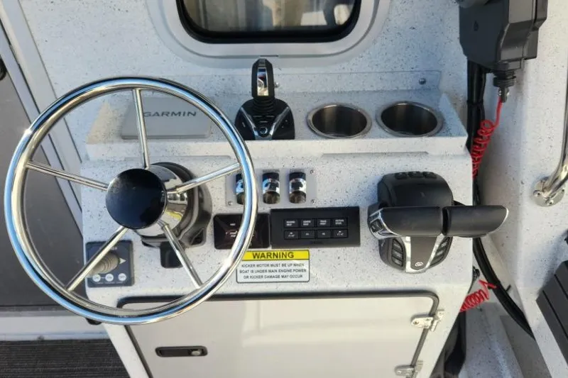 Slide: The Image of Control panel of 2023 KingFisher 3025 Destination boat with steering wheel and controls. - 8