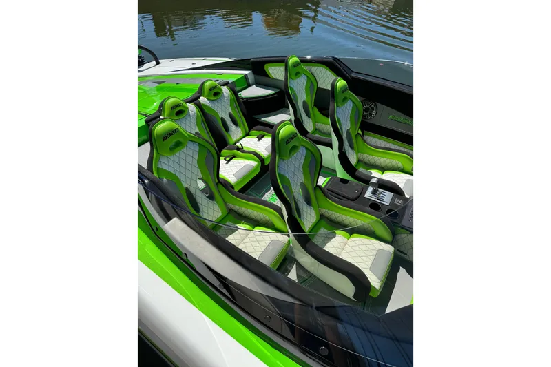 Slide: The Image of 2025 Performance Powerboats P360 interior with green and white seats, docked by water. - 7