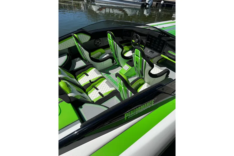 Slide: The Image of 2025 Performance Powerboats P360 interior with green and white seating, docked on water. - 9