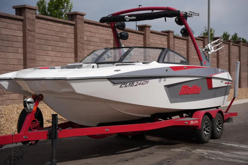 Slide: The Image of 2022 Malibu Wakesetter 23 MXZ boat on red trailer, parked outdoors. - 7