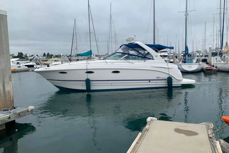 Slide: The Image of 2003 Chaparral Signature 320 boat docked in a marina with sailboats. - 1