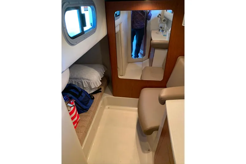 Slide: The Image of 2003 Chaparral Signature 320 cabin interior with bed, mirror, and seating area. - 16