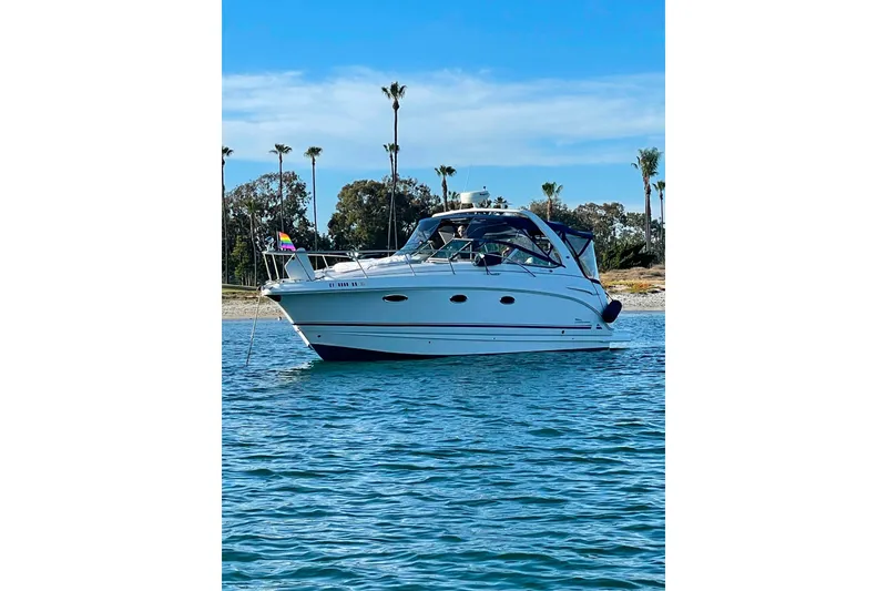 Slide: The Image of 2003 Chaparral Signature 320 boat anchored on calm water with palm trees in background. - 3