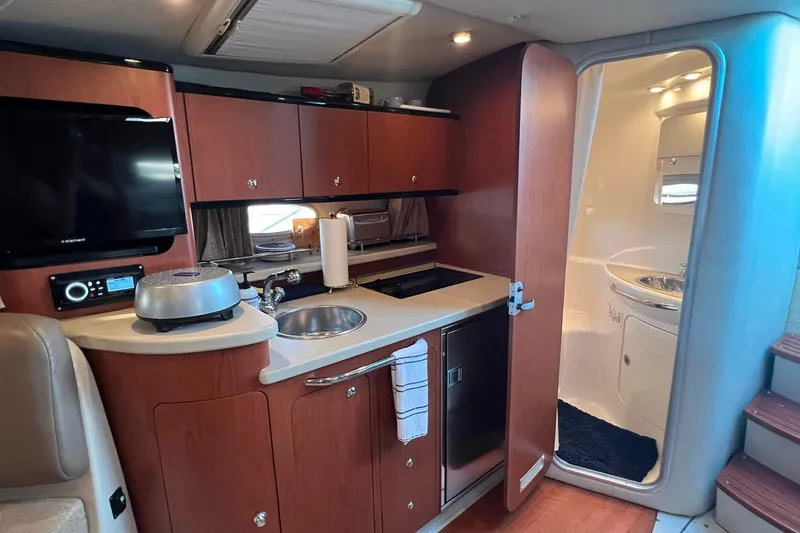 Slide: The Image of 2003 Chaparral Signature 320 yacht interior with kitchenette and bathroom. - 6