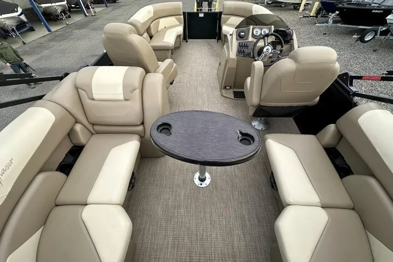 Slide: The Image of 2024 SunChaser Geneva Cruise 20 LR DH pontoon boat interior with beige seating and central table. - 8