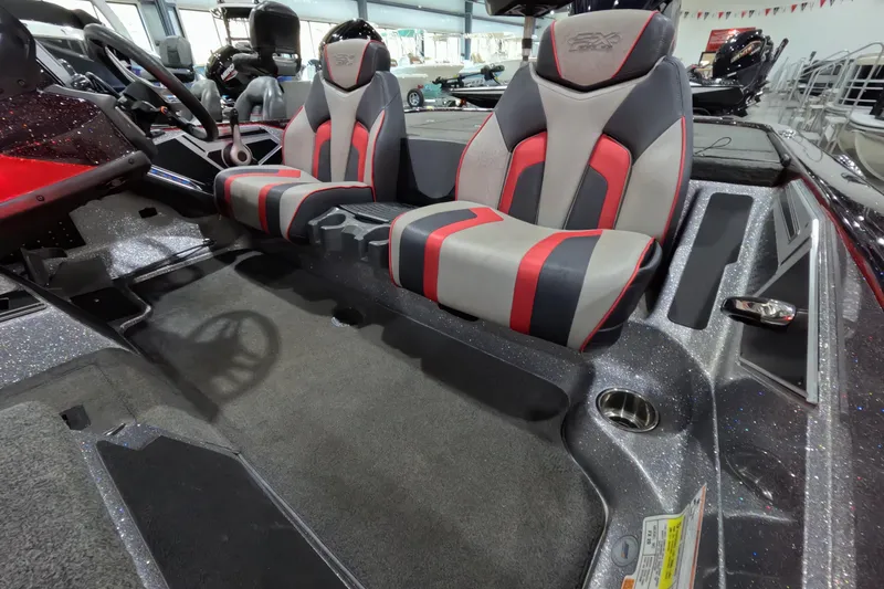 Slide: The Image of 2017 Skeeter FX20 boat interior with dual red and gray seats, steering wheel, and carpeted flooring. - 4