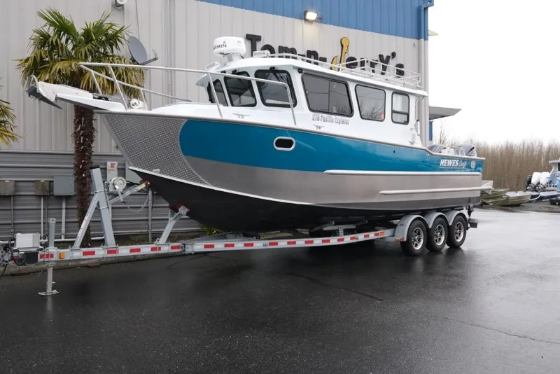 The Image of 2024 Hewescraft 270 Pacific Explorer ET Hardtop on trailer, parked outside a building. - 1