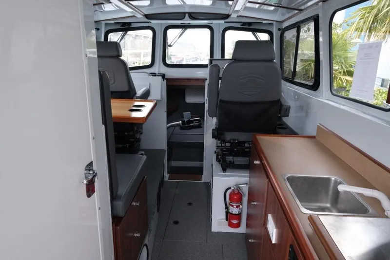 Slide: The Image of 2024 Hewescraft 270 Pacific Explorer ET Hardtop interior with seating, table, and kitchenette. - 10