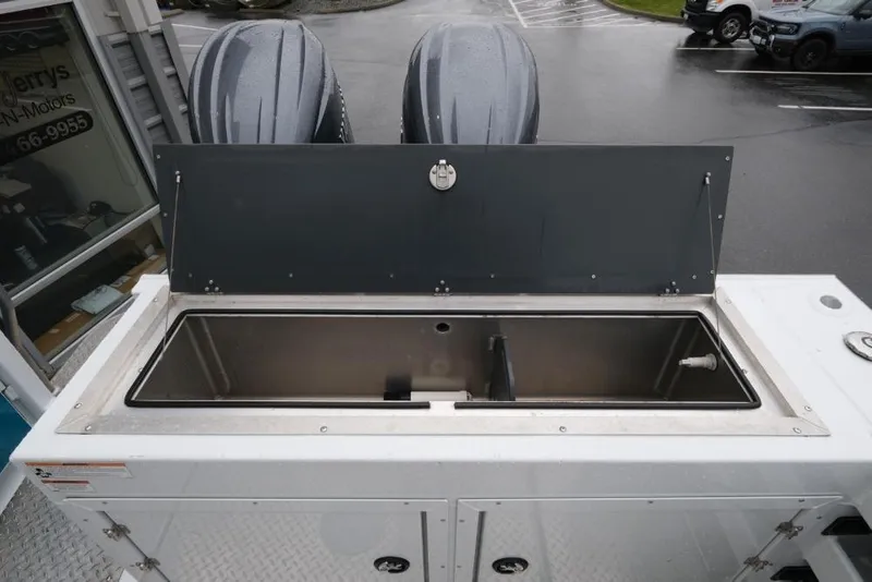 Slide: The Image of 2024 Hewescraft 270 Pacific Explorer ET Hardtop with dual outboard motors and open storage compartment. - 22