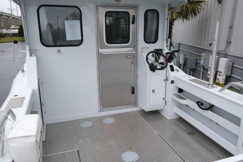 Slide: The Image of 2024 Hewescraft 270 Pacific Explorer ET Hardtop boat deck with steering wheel and metal flooring. - 7