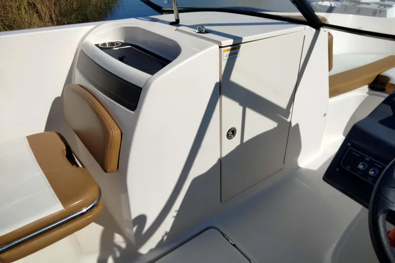 Slide: The Image of 2022 Bayliner VR6 Bowrider OB interior with tan seating and storage compartment. - 15
