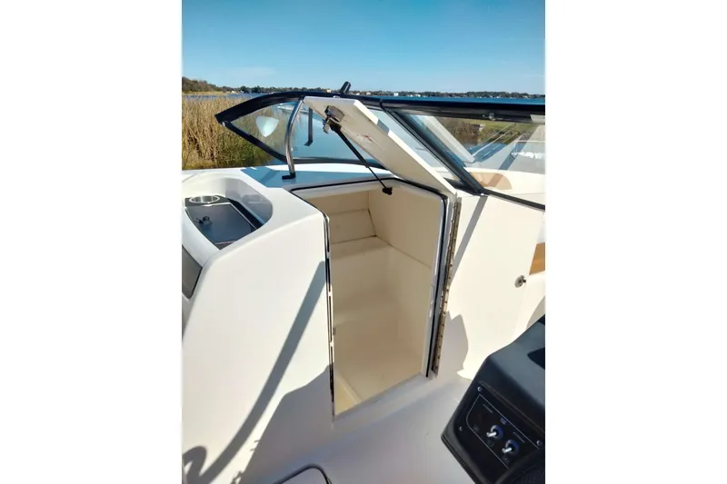 Slide: The Image of 2022 Bayliner VR6 Bowrider OB interior cabin with open door, showcasing sleek design. - 16