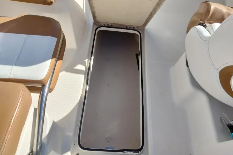 Slide: The Image of 2022 Bayliner VR6 Bowrider OB interior storage compartment with brown and white seating. - 23