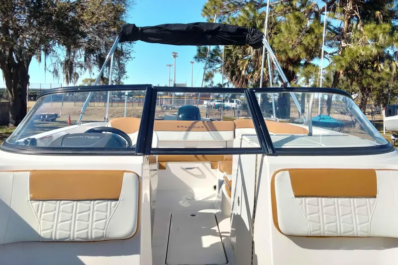 Slide: The Image of 2022 Bayliner VR6 Bowrider OB interior with tan and white seating, outdoors. - 25