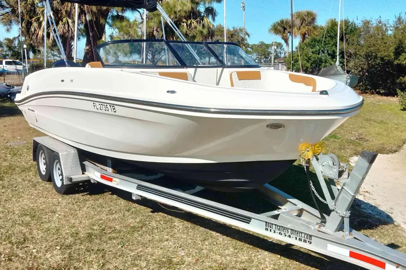 Slide: The Image of 2022 Bayliner VR6 Bowrider OB on trailer, parked outdoors with palm trees in background. - 5