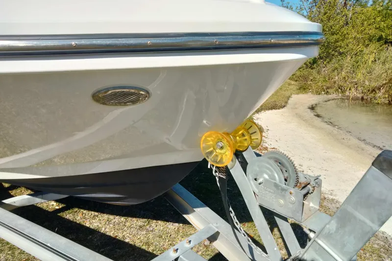 Slide: The Image of 2022 Bayliner VR6 Bowrider OB on trailer near water, showcasing bow detail. - 6