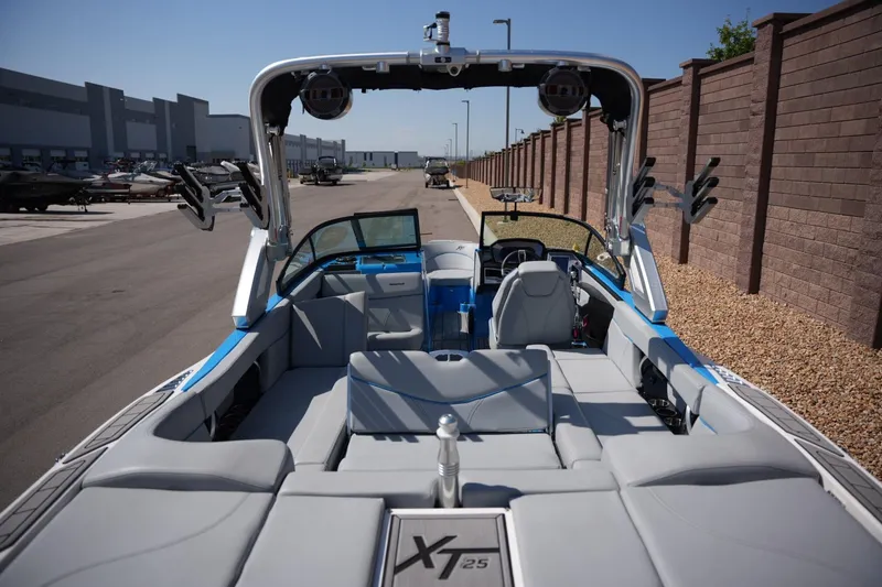 Slide: The Image of 2021 MasterCraft XT25 boat interior with gray seating and wakeboard racks. - 17