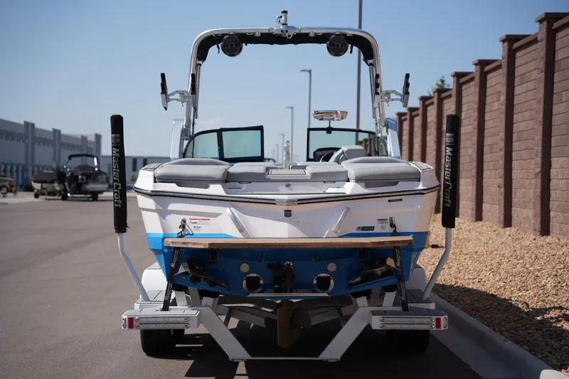 Slide: The Image of 2021 MasterCraft XT25 boat parked on a sunny street, rear view. - 3