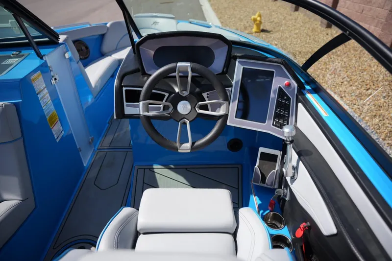 Slide: The Image of Interior of a 2021 MasterCraft XT25 boat, featuring a modern steering wheel and control panel. - 10