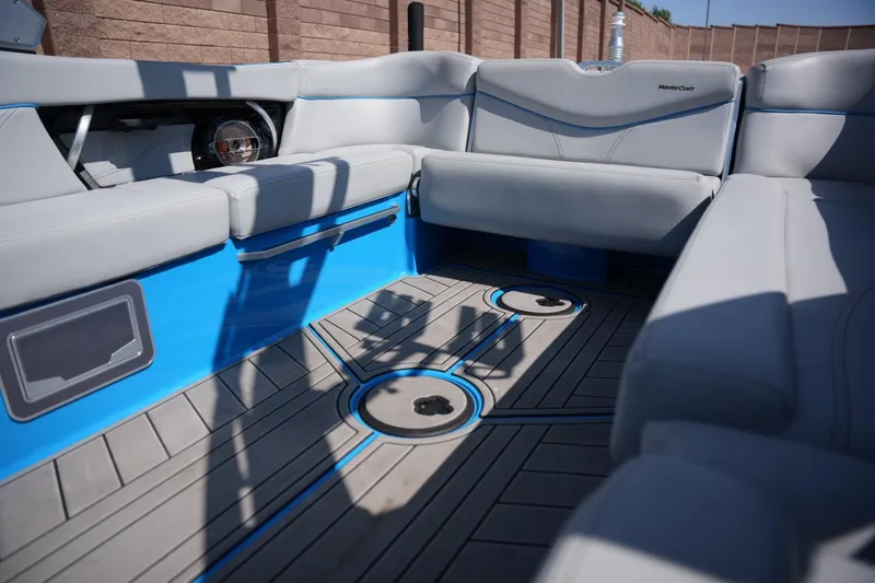 Slide: The Image of Interior of 2021 MasterCraft XT25 boat with gray seating and blue accents. - 12