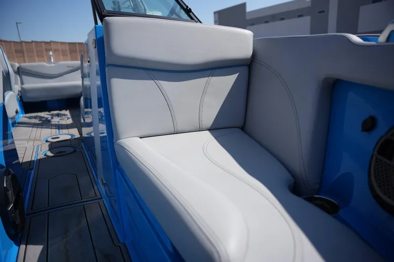 Slide: The Image of 2021 MasterCraft XT25 boat interior with blue accents and gray seating. - 9