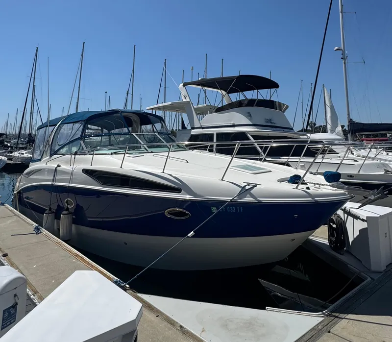 The Image of 2006 Bayliner 325 boat docked at marina, surrounded by other vessels. - 0