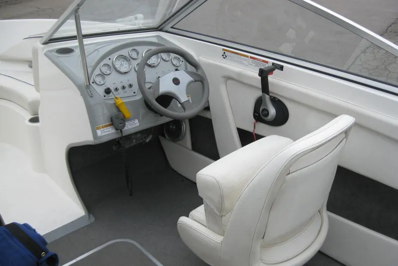 Slide: The Image of Interior of a 2013 Bayliner 195 Discovery boat showing steering wheel and controls. - 11