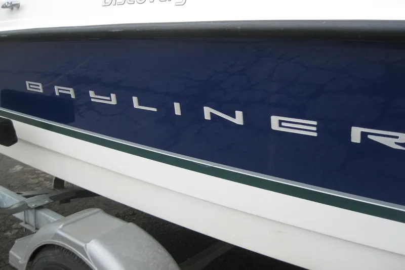 Slide: The Image of 2013 Bayliner 195 Discovery boat side view with logo on trailer. - 3