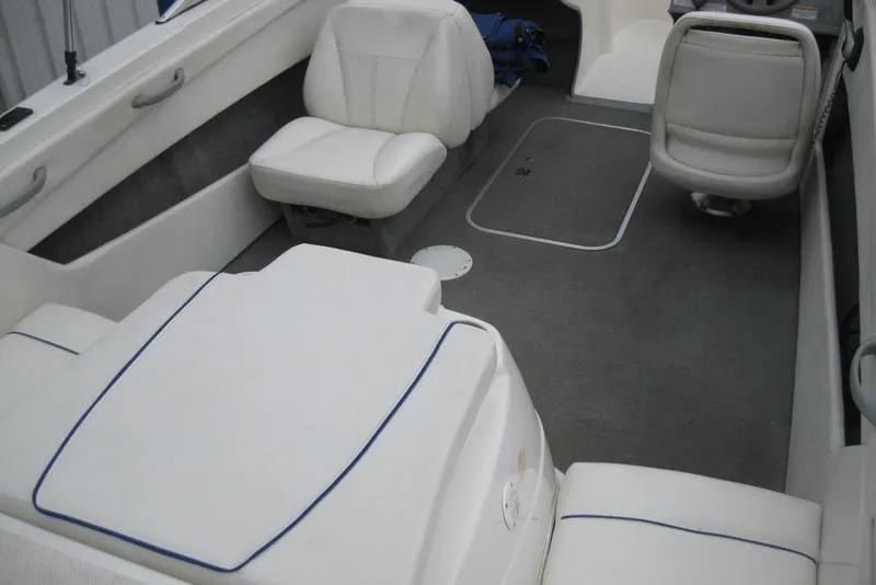 Slide: The Image of Interior of a 2013 Bayliner 195 Discovery boat with white seating and gray flooring. - 8