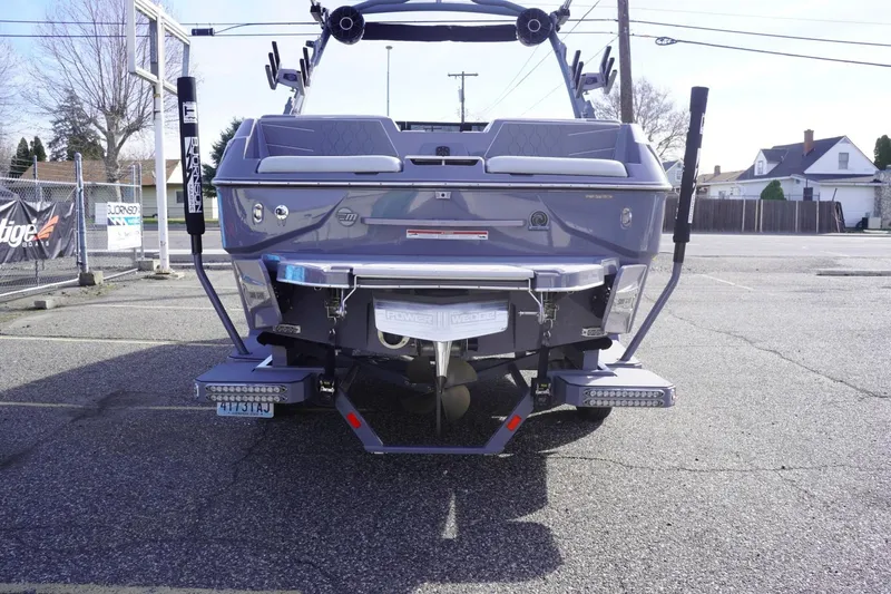 Slide: The Image of 2023 Malibu M220 boat rear view in a parking lot, showcasing sleek design and features. - 10