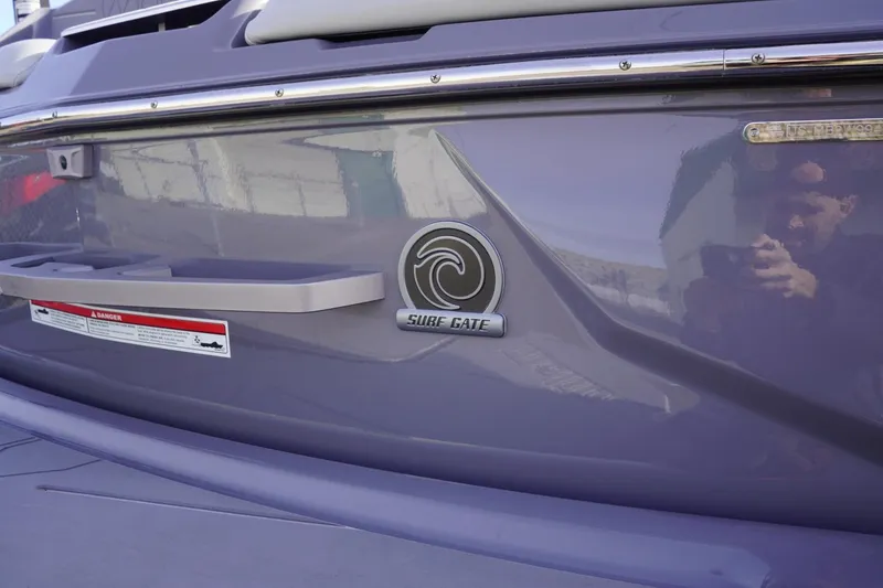 Slide: The Image of 2023 Malibu M220 boat with Surf Gate feature, close-up view. - 14