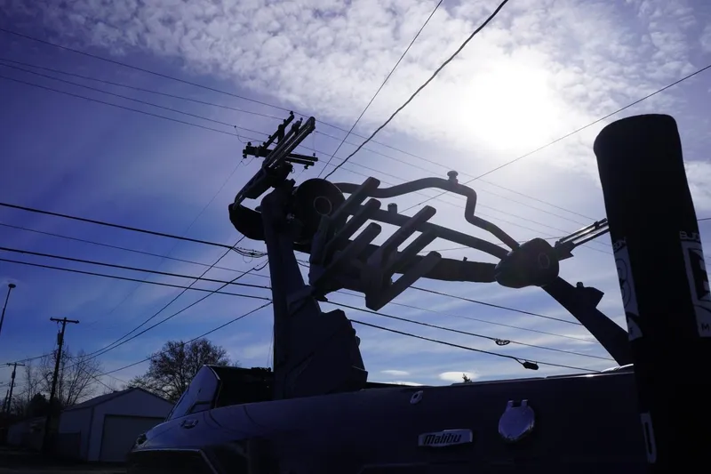 Slide: The Image of 2023 Malibu M220 boat silhouette against a bright sky with power lines. - 17