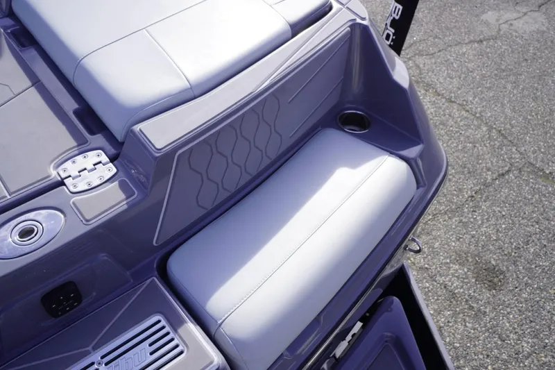 Slide: The Image of 2023 Malibu M220 boat interior with cushioned seating and cup holder. - 18
