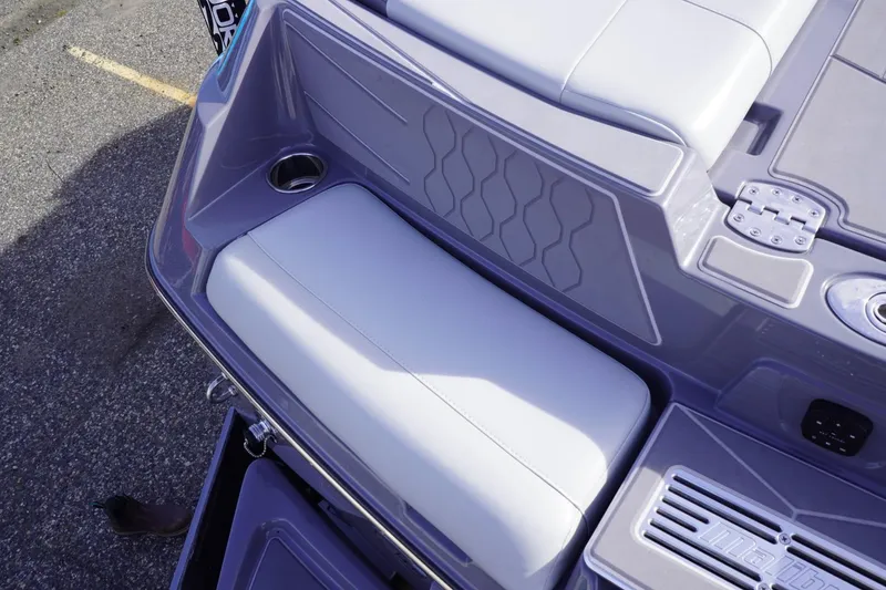 Slide: The Image of 2023 Malibu M220 boat interior with cushioned seating and cup holder. - 20