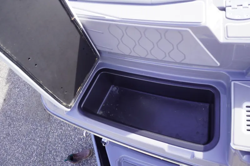 Slide: The Image of Open storage compartment in 2023 Malibu M220 boat, showcasing interior space. - 21