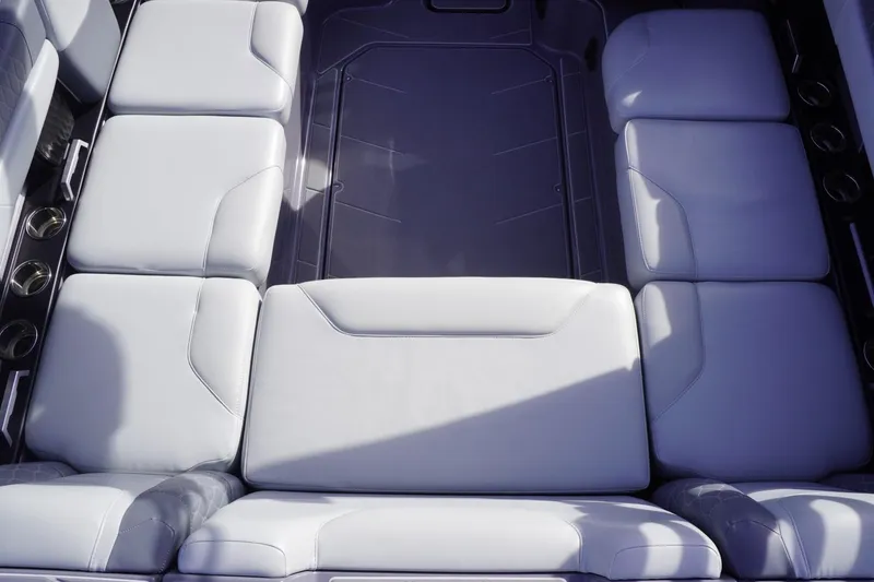 Slide: The Image of 2023 Malibu M220 boat interior with luxurious white seating and cup holders. - 28
